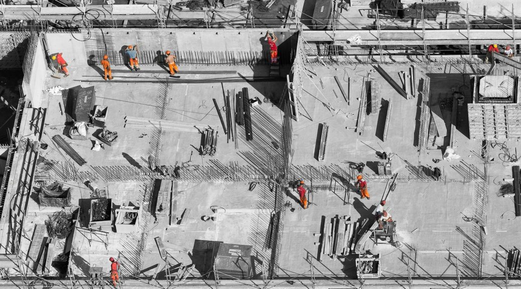 selective color photo of man on top of gray building