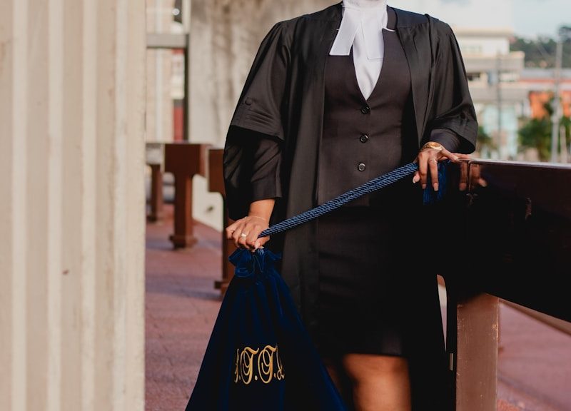 a woman in a black dress holding a blue bag